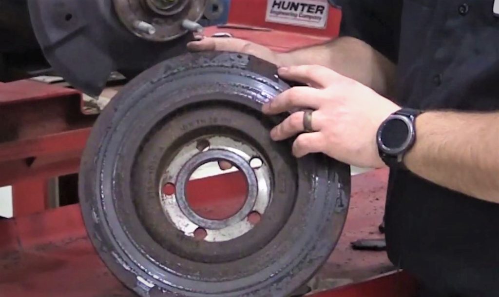 close up of rusted brake rotor being held by mechanic to demonstrate rust jacking
