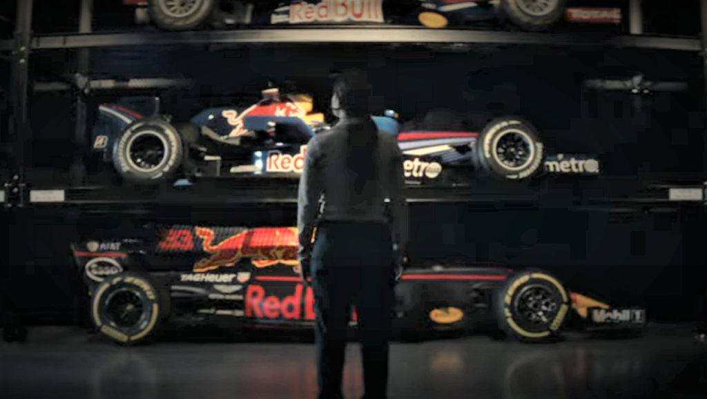 Woman Standing in front of formula one red bull cars