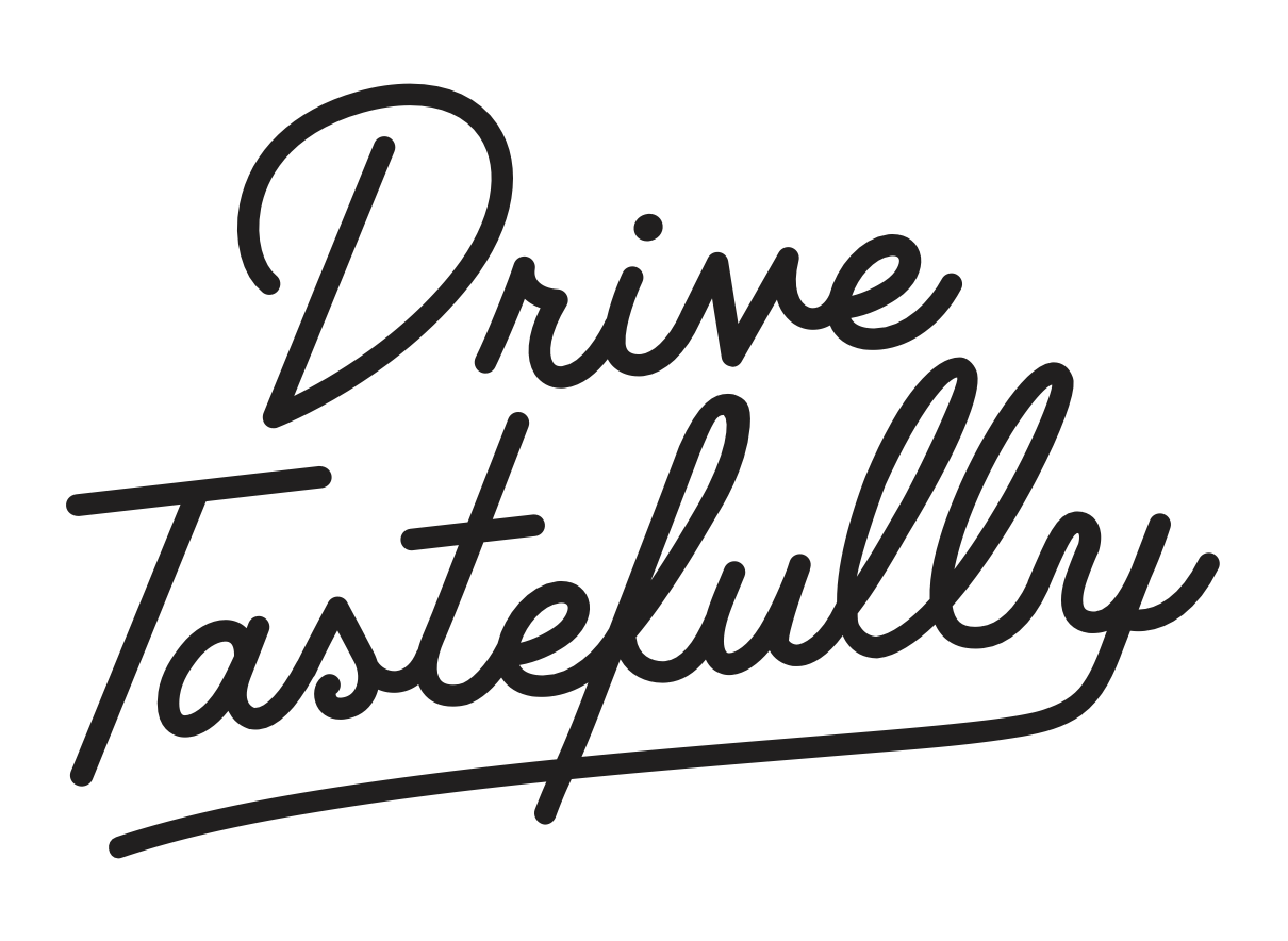 A black decal with the phrase 'Drive Tastefully' written in a cursive white font.