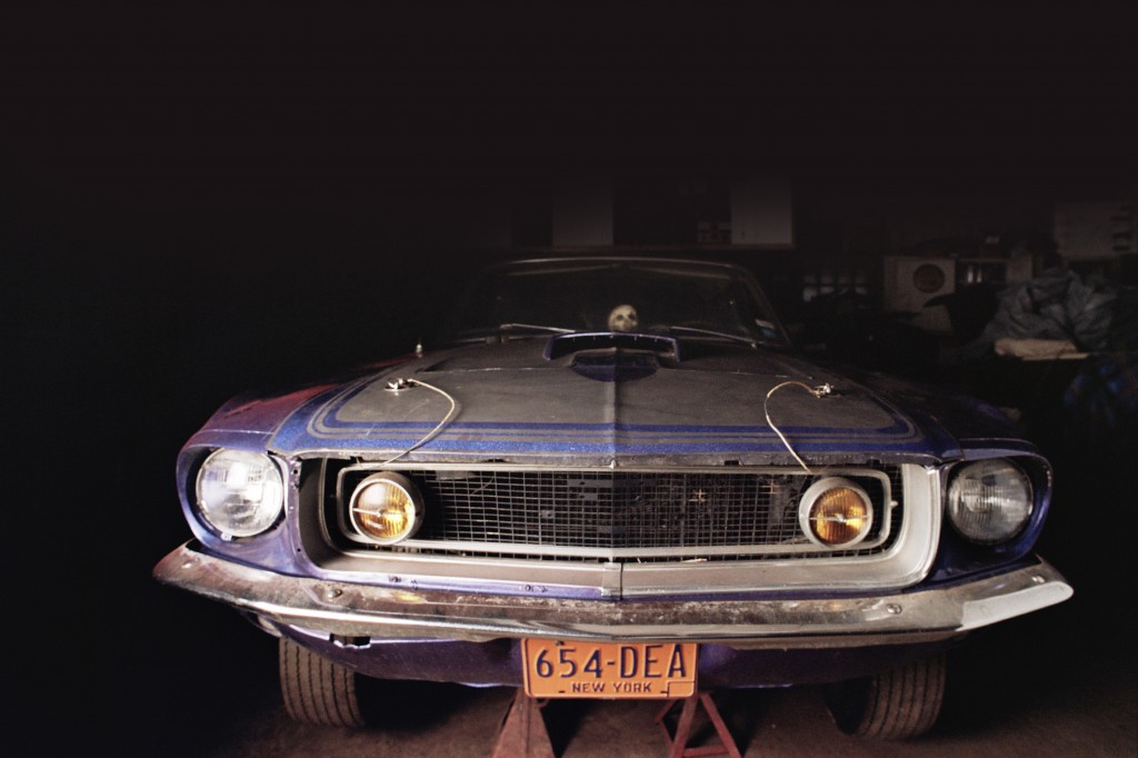 vintage ford mustang in a shadowy barn shop