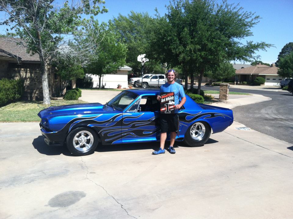 man standing with first gen ford mustang race car