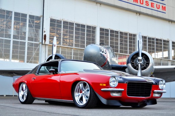 1972 Chevy Custom Camaro outside hangar with military prop plane