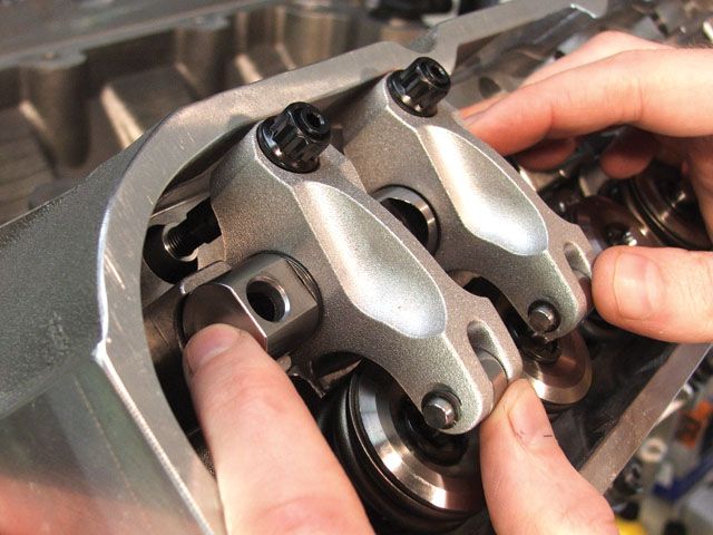 man adjusting rocker arms on a cylinder head