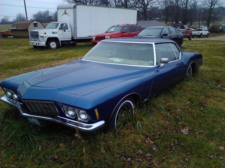 1971 buick riviera parked in a grassy lot