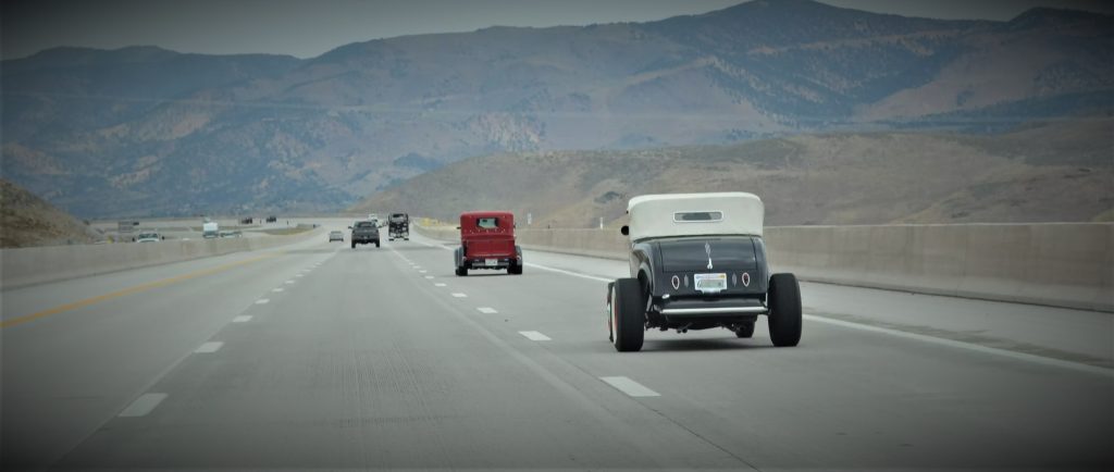 Vintage Hot rods driving on desert highway