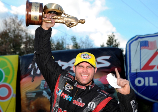 matt hagan hoists a wally nhra trophy