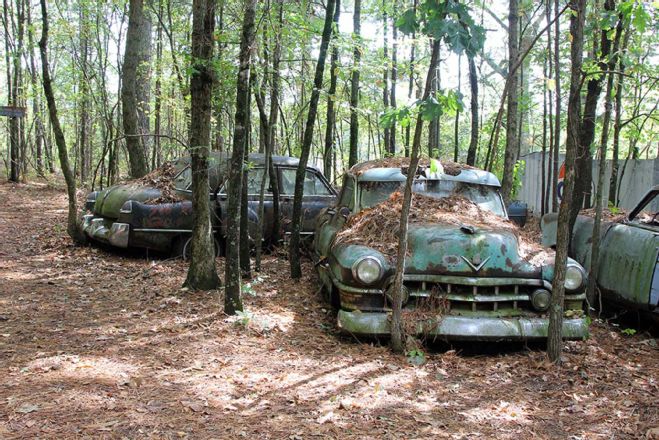 old cars covered in dirt and leaves