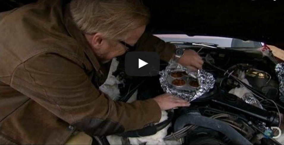 man cooking dinner on an engine