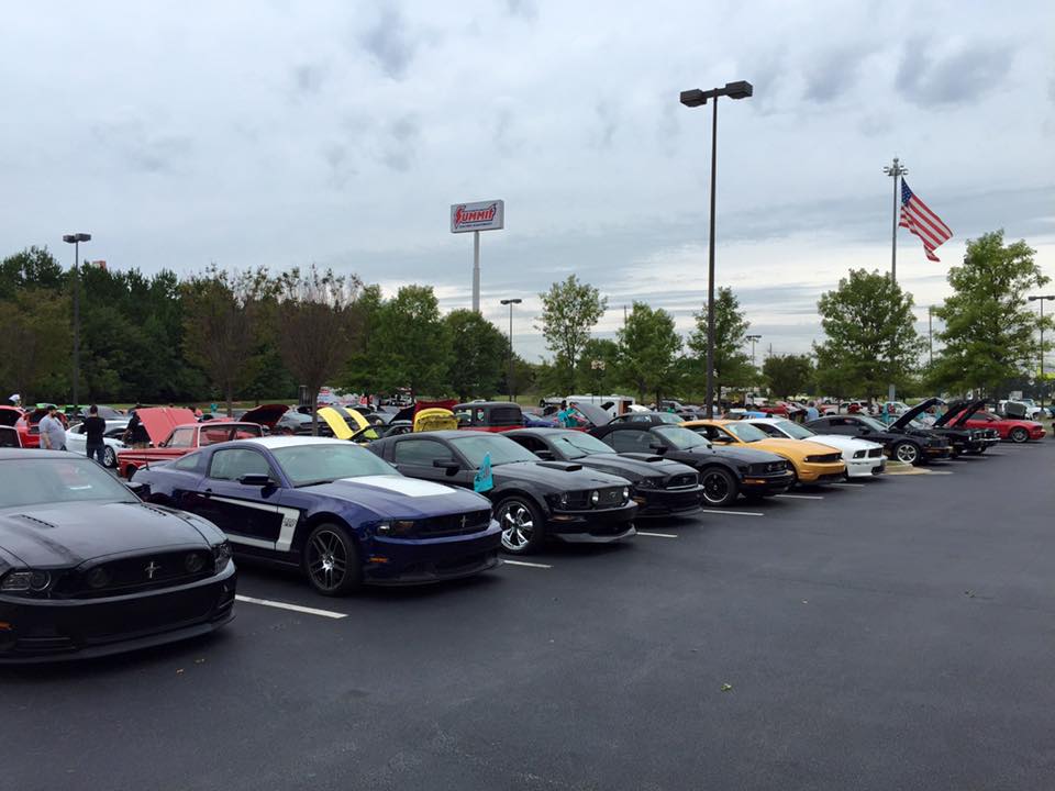 row of mustangs parked at ford car show