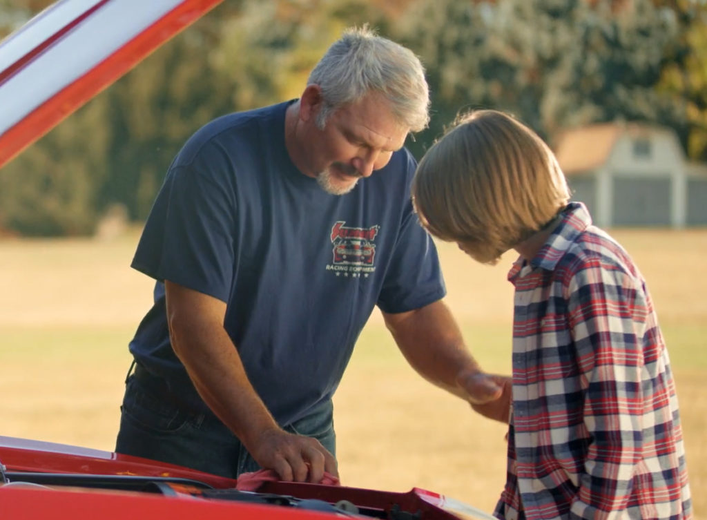 a father and son working together on a classic car