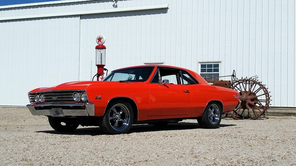 classic chevy chevelle in front of a large barn