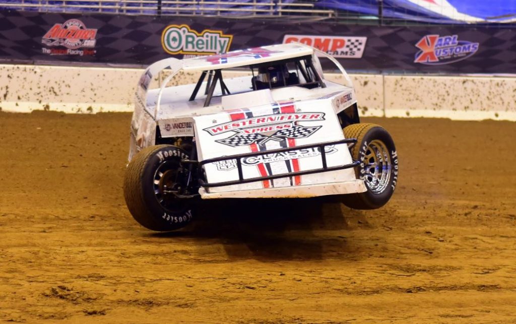 a circle track car sliding on a dirt track