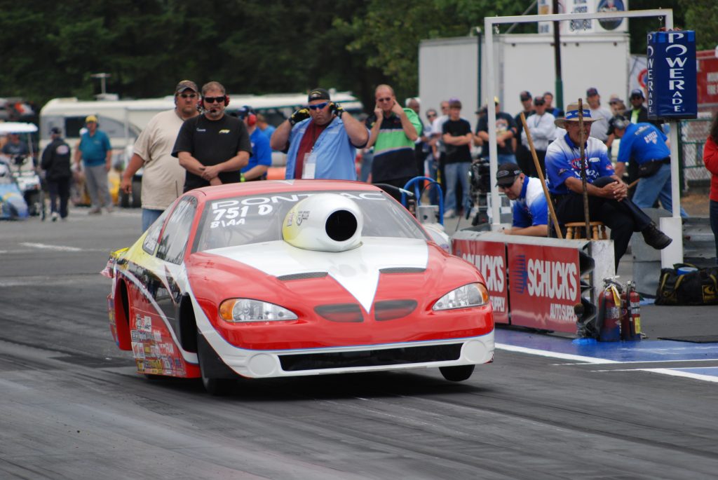 pontiac pro stock nhra race car launching on a dragstrip track