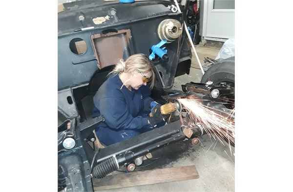 kat jones grinding the frame in her 1954 studebaker commander hot rod