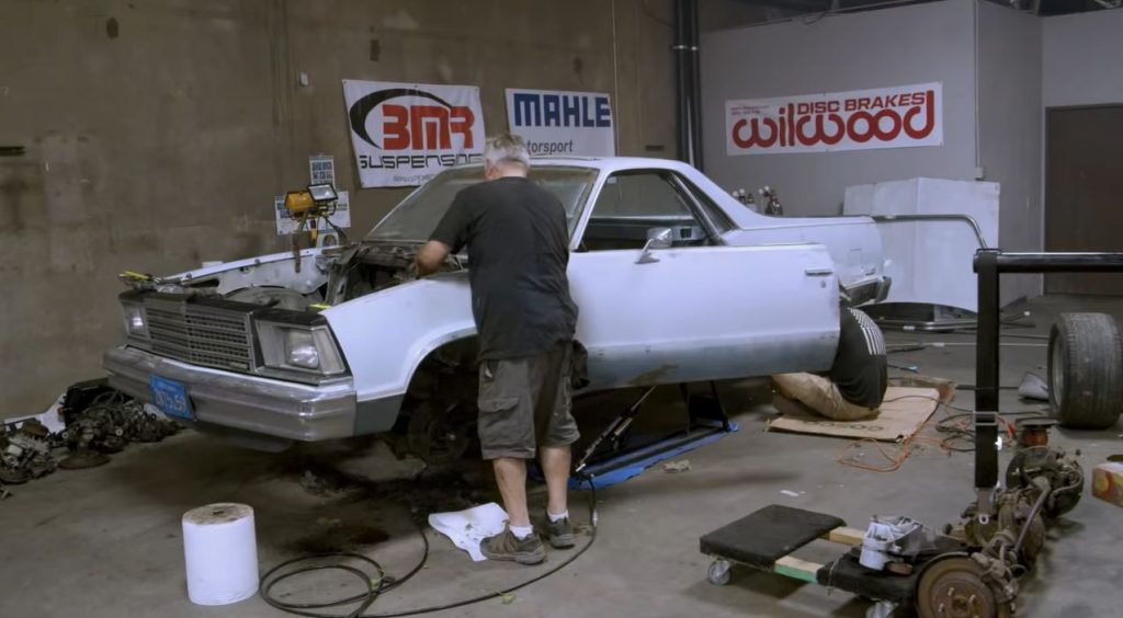 man working on el camino drag race car