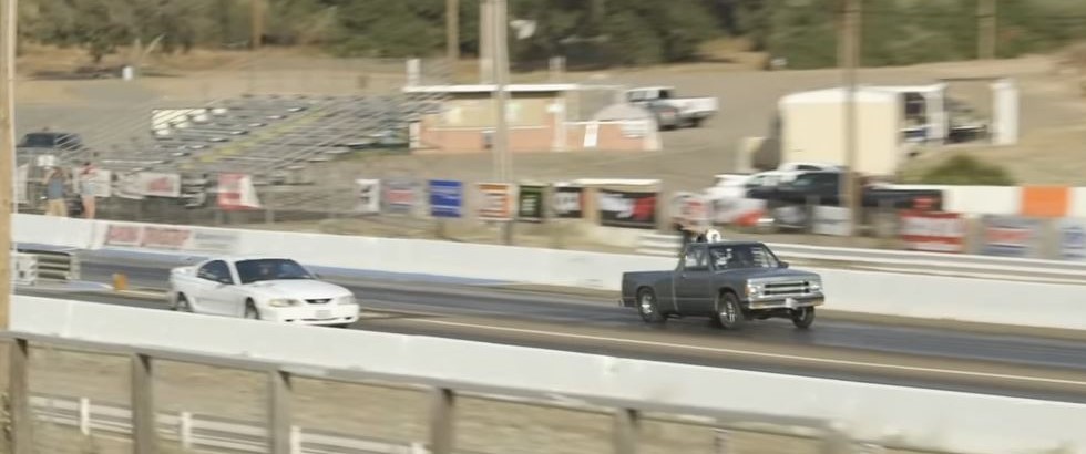 a mustang and an s-10 truck race on a drag strip