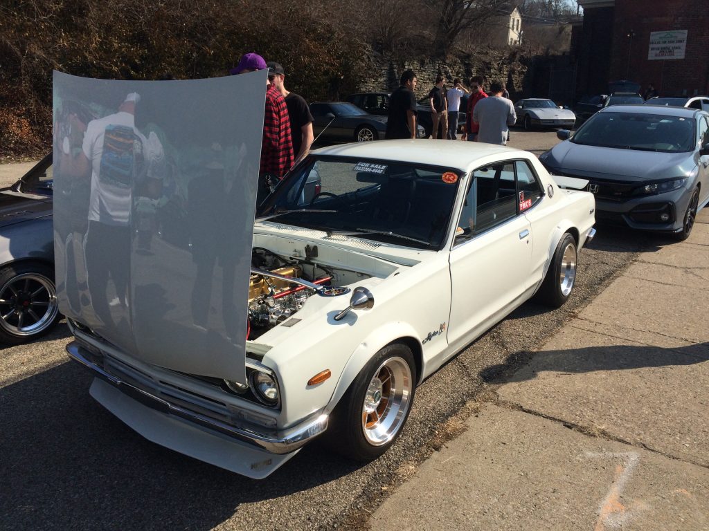 white nissan skyline gtr at a classic car show