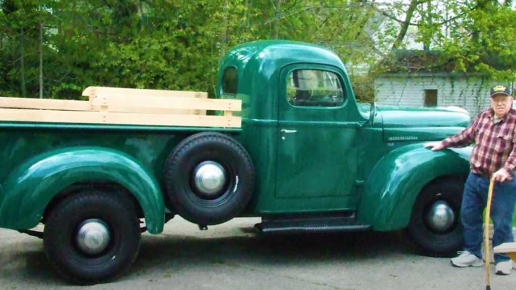 man in front of restored international kb2 pickup truck