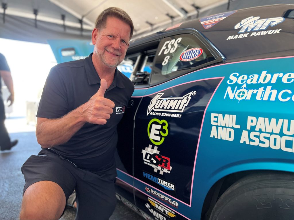 nhra drag racer Mark Pawuk poses in front of his summit racing sponsored dragster prior to summit racing nhra nationals in 2022