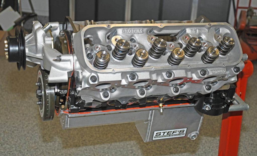 a cylinder head installed on a big block chevy v8 engine attached to a rolling engine stand