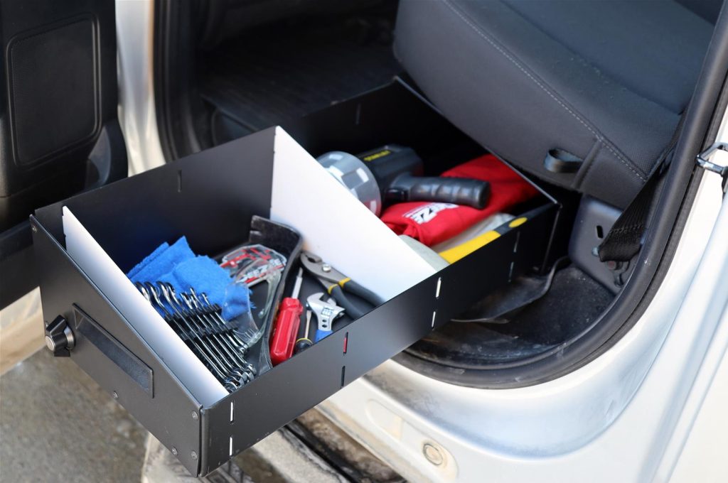 view of dee zee under seat storage drawr as it sildes out under the seat of a ford f1-50 to reveal what's inside