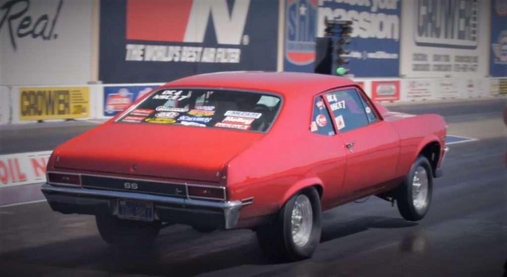 Red Chevy Nova race car Launching at Drag Strip