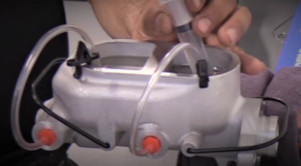 Bench bleeding a brake master cylinder with a fluid syringe tool