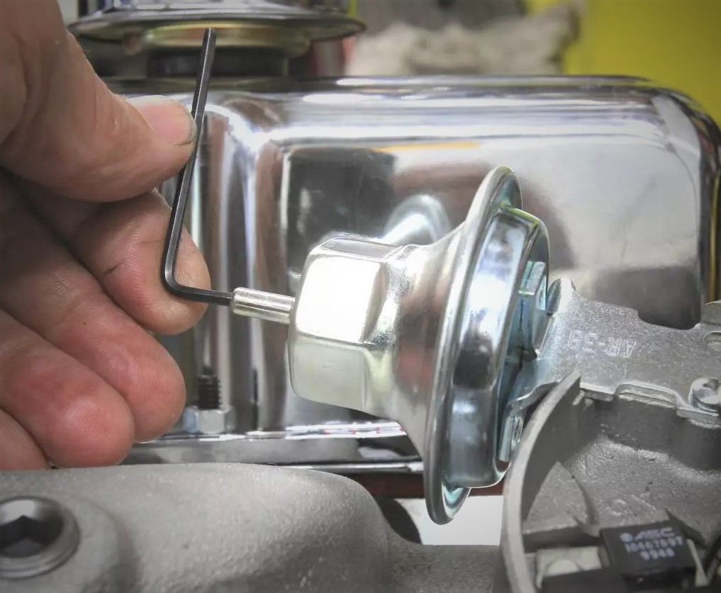 man adjusting vacuum advance canister on a distributor