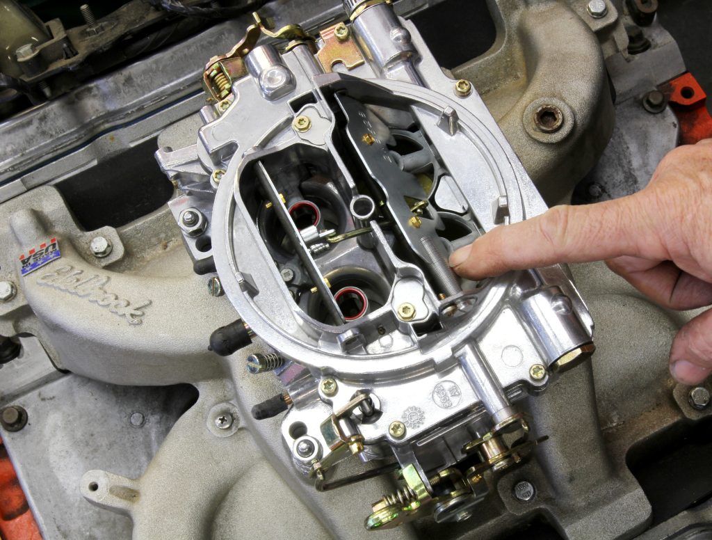 man holding up throttle blades on an edelbrock avs carburetor