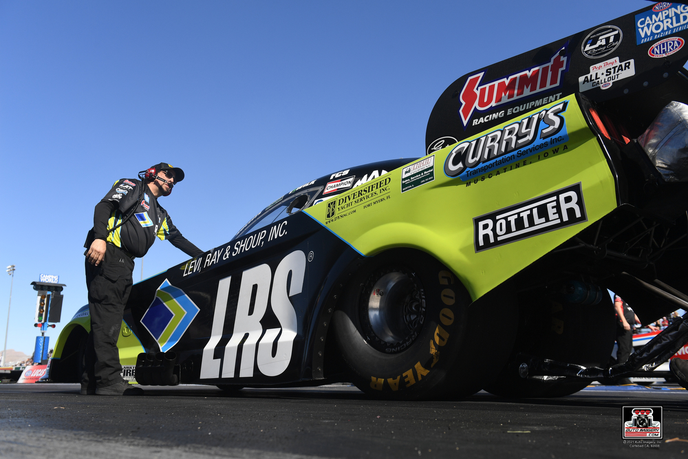 Funny Car crewman wearing ear muff hearing protection during race