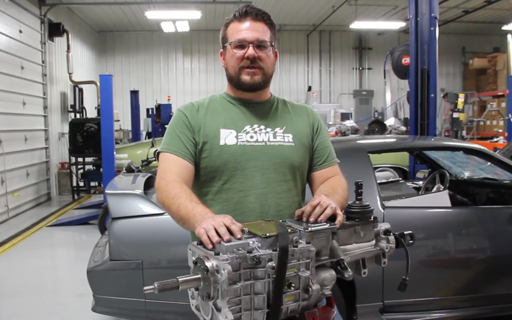man explaining a transmission install in professional garage shop