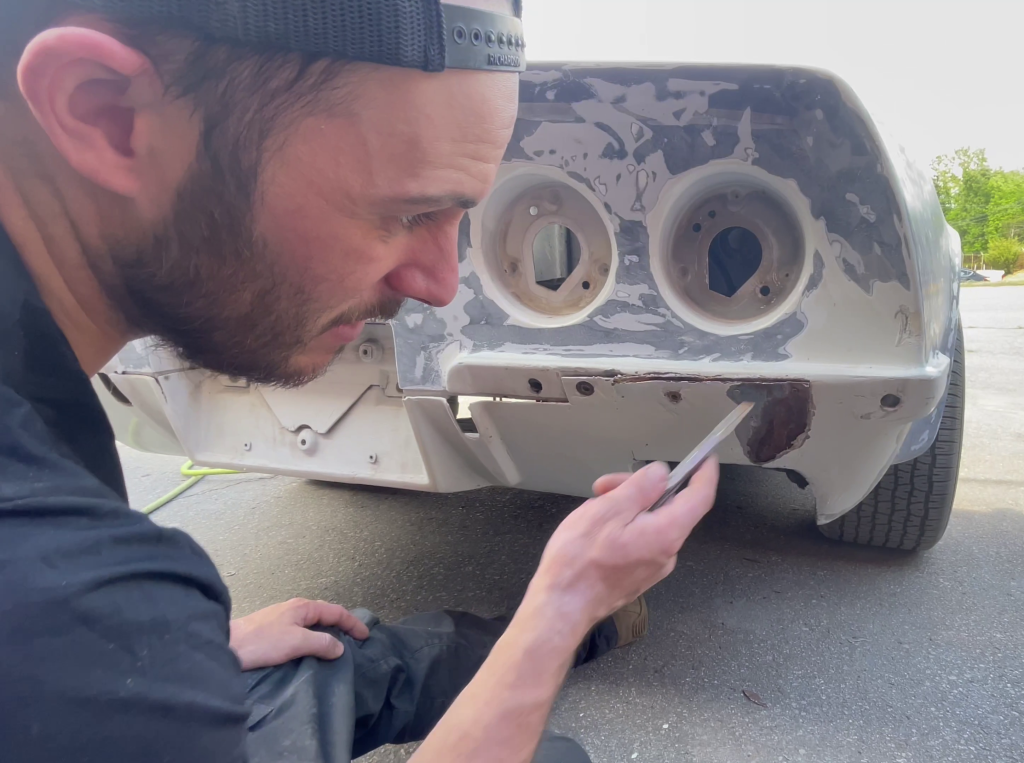 man repairing tail panel on a 1970 chevy corvette
