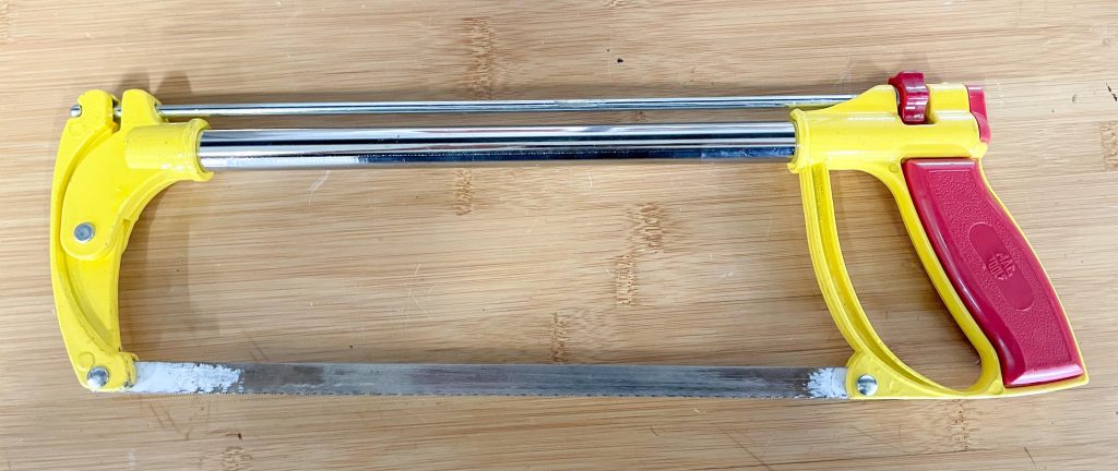 hacksaw laying on workbench