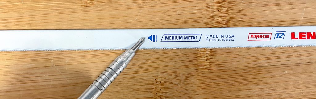 close up of hacksaw blade direction arrow