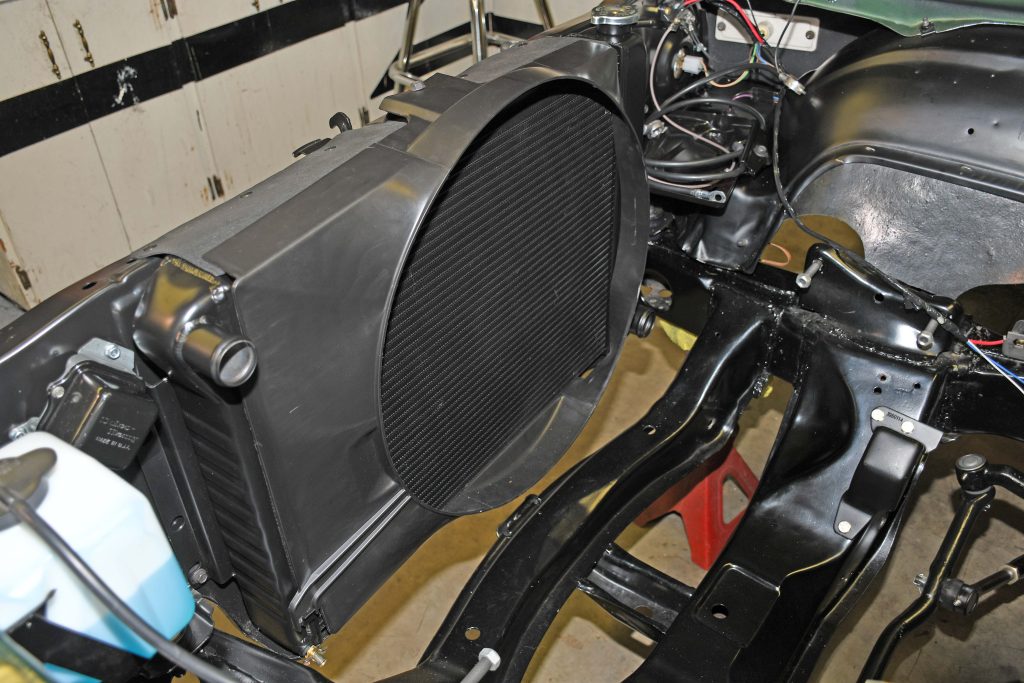 radiator with fan shroud installed in engine bay of an old car