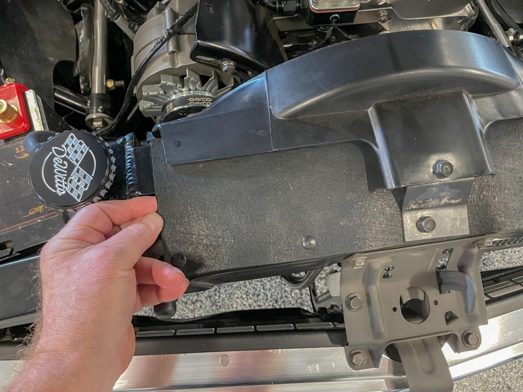 man installing fan shroud cover on radiator