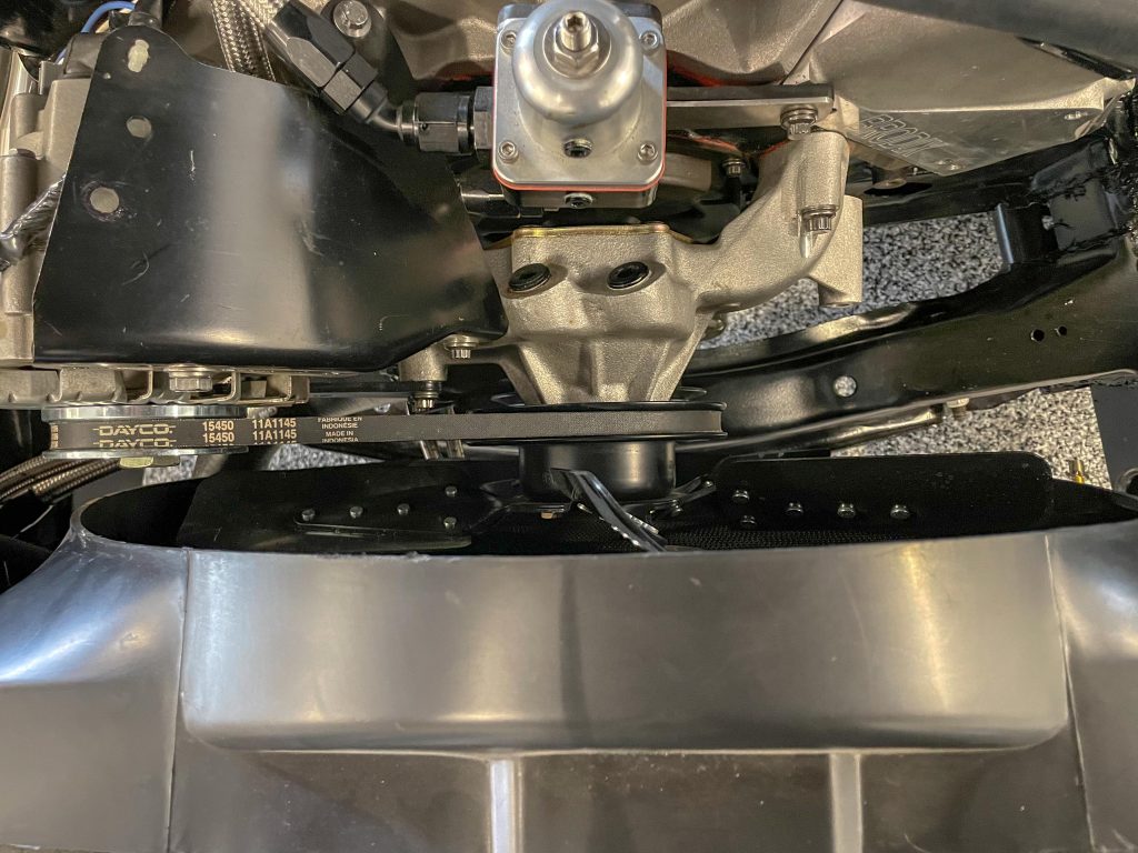 vertical top view of a radiator, fan shroud, and water pump in a v8 muscle car