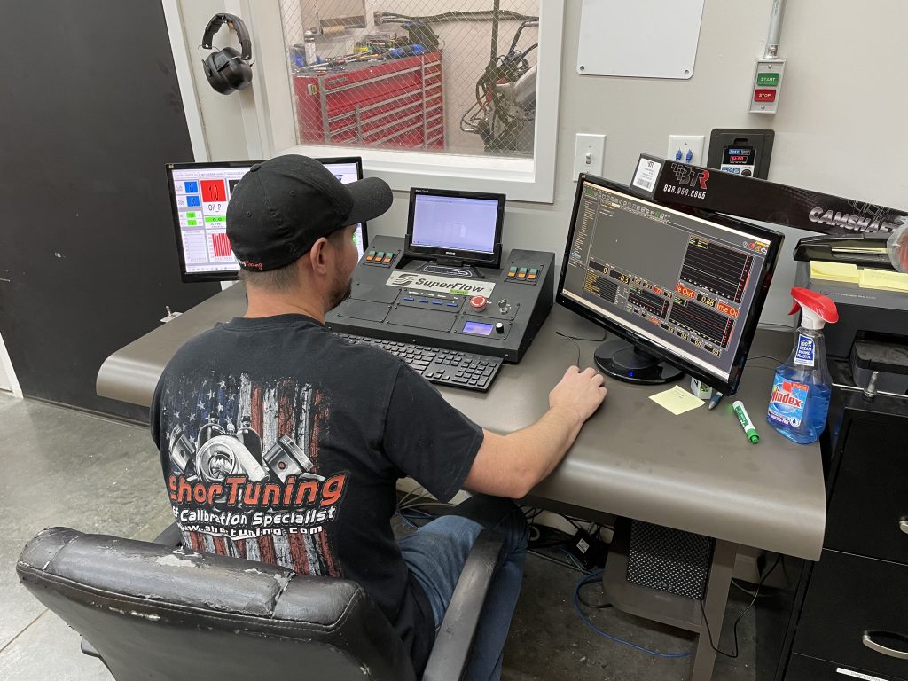 Man sitting at control desk of an engine dyno