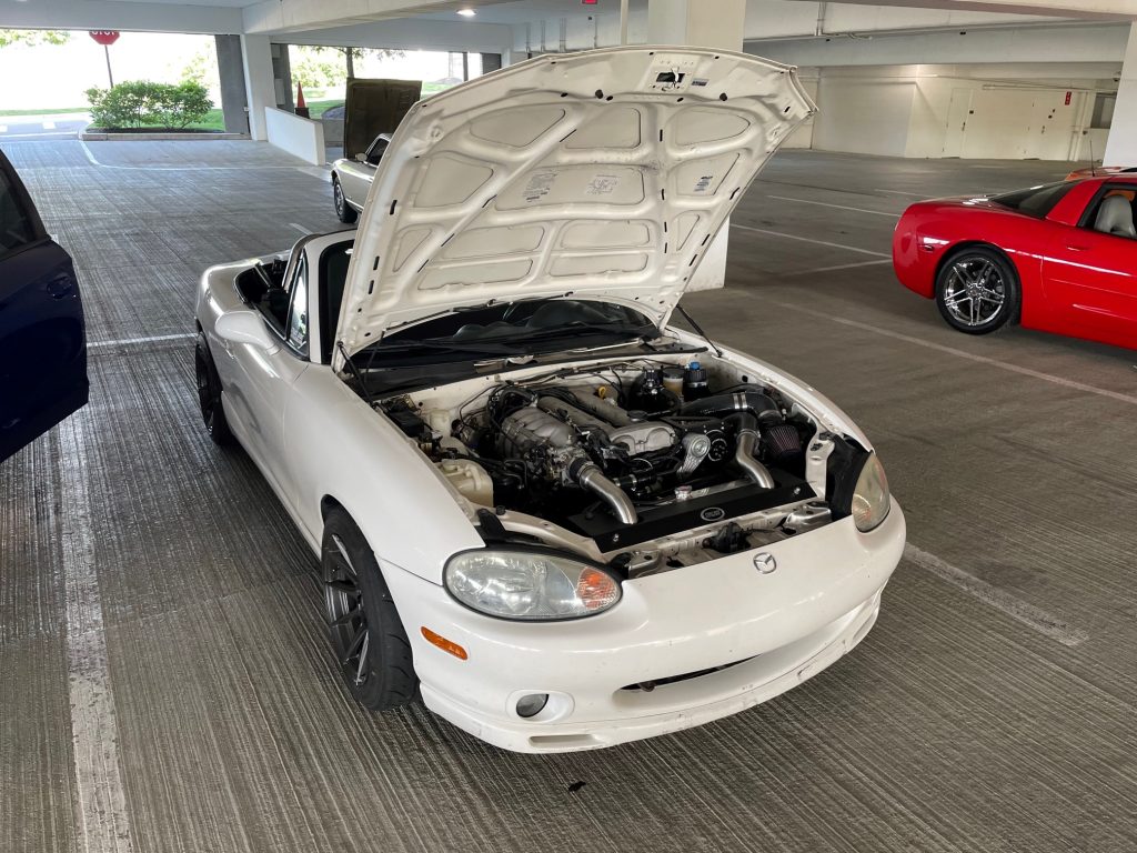 white mazda miata roadster with hood open