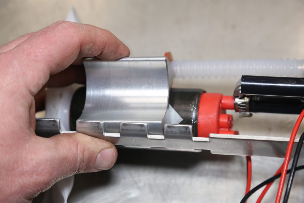 man holding the bottom part of an in-tank fuel pump