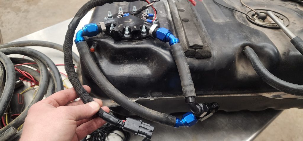 man holding electrical harness for a vehicle fuel pump