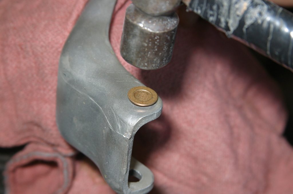 hammering in a brass bushing in a car door hinge