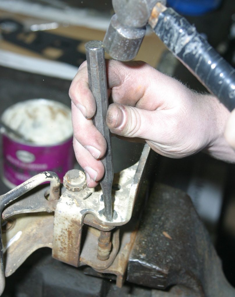 hammering out an old hinge pin in a car door