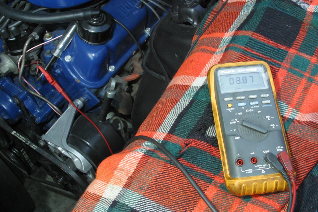 a multimeter resting on a vintage car fender