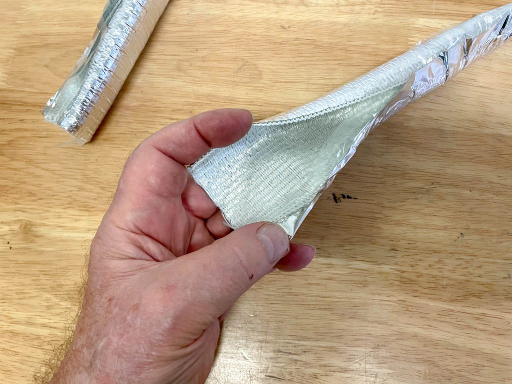 man opening a heat shield wire hose wrap