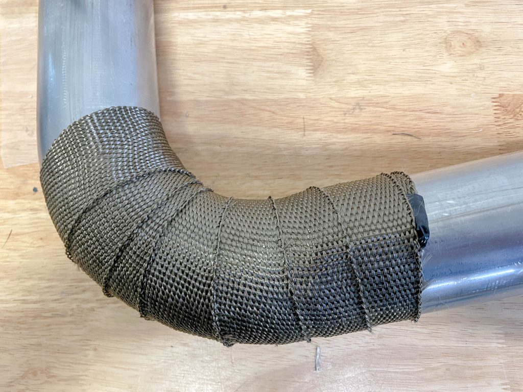 a bent section of exhaust tubing with heat wrap