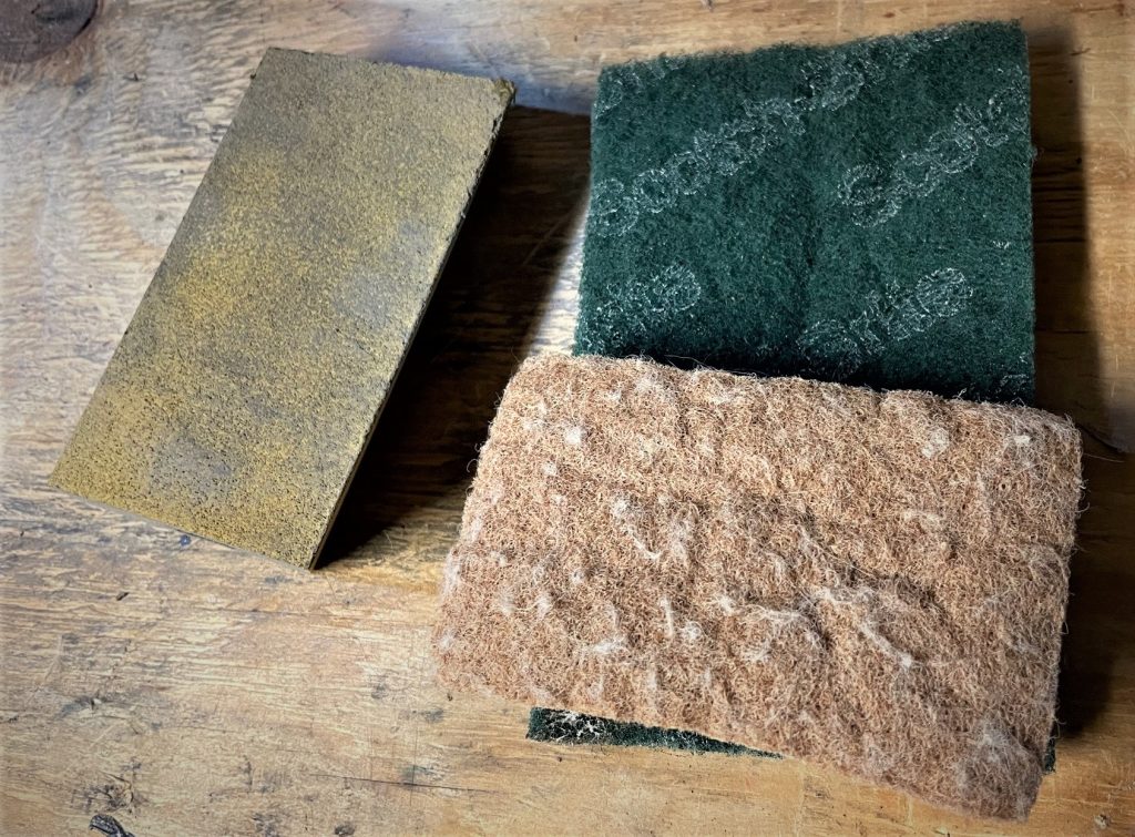 drywall sanding sponge and scotch brite pad on table