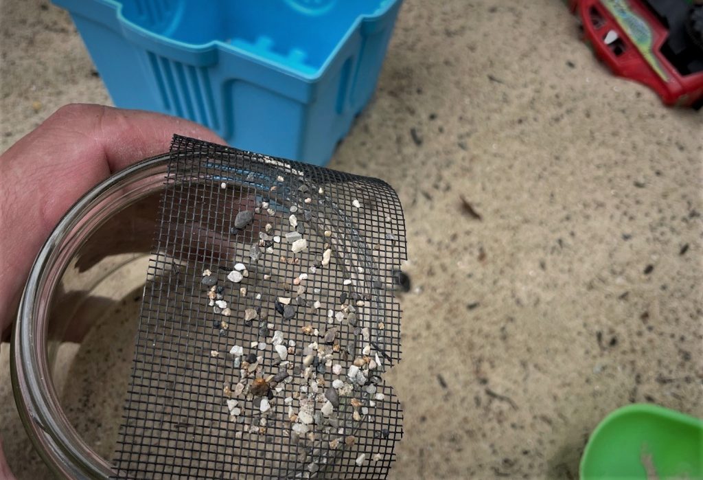 cleaning play sand through a sieve