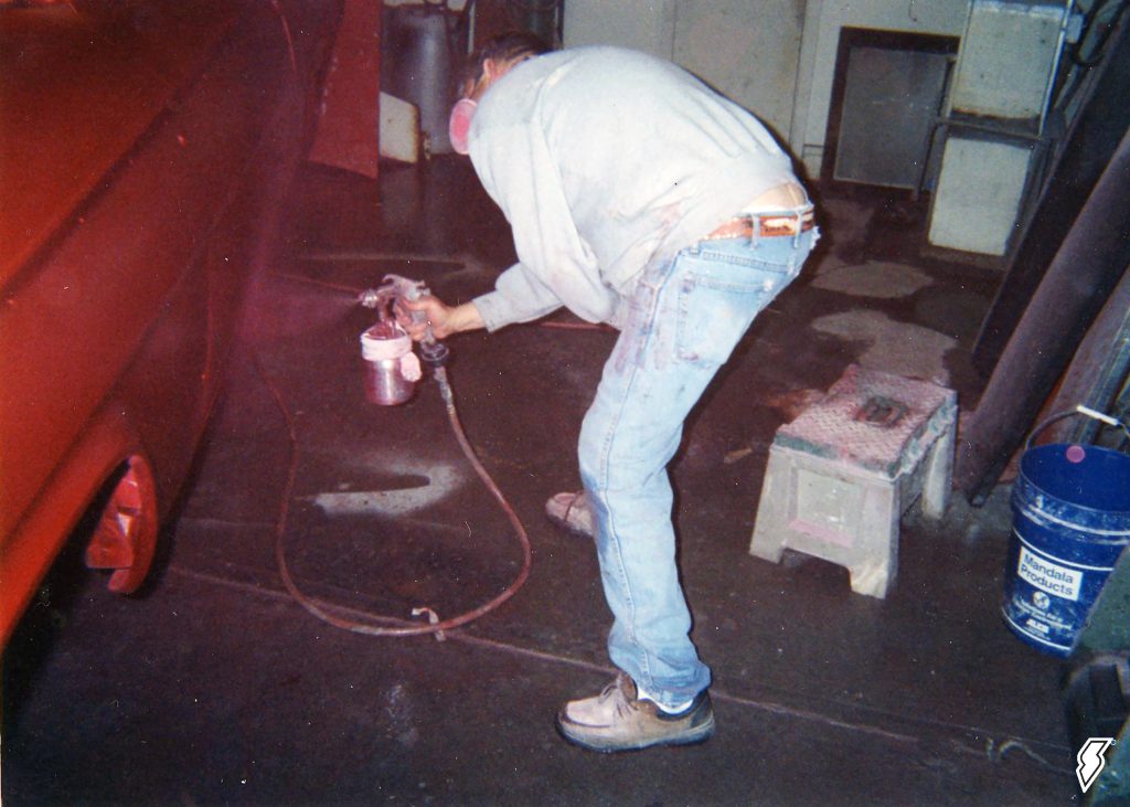 man painting a 1962 chevy impala drag car