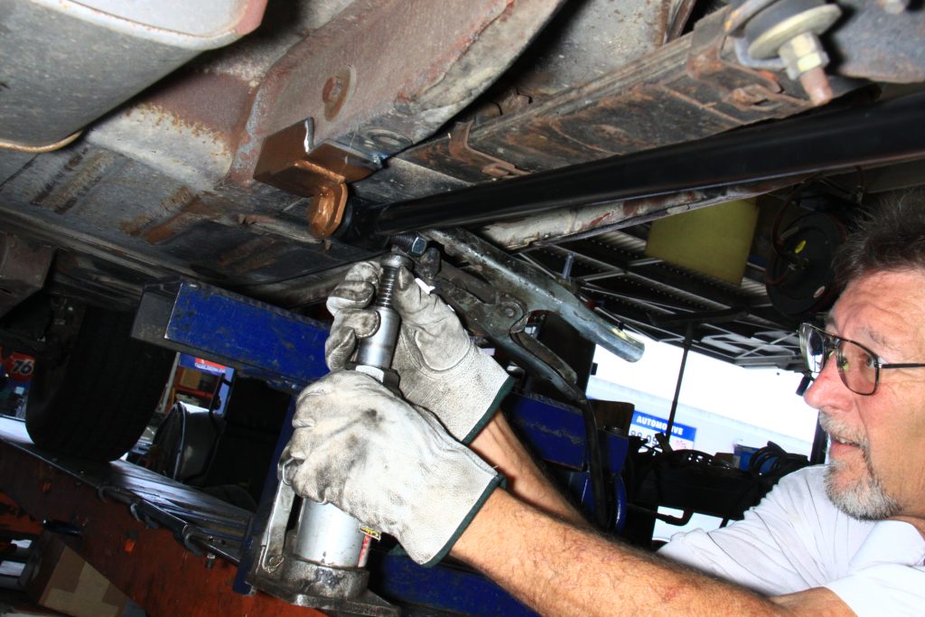 adjusting mount plate location for a traction bar on an old car